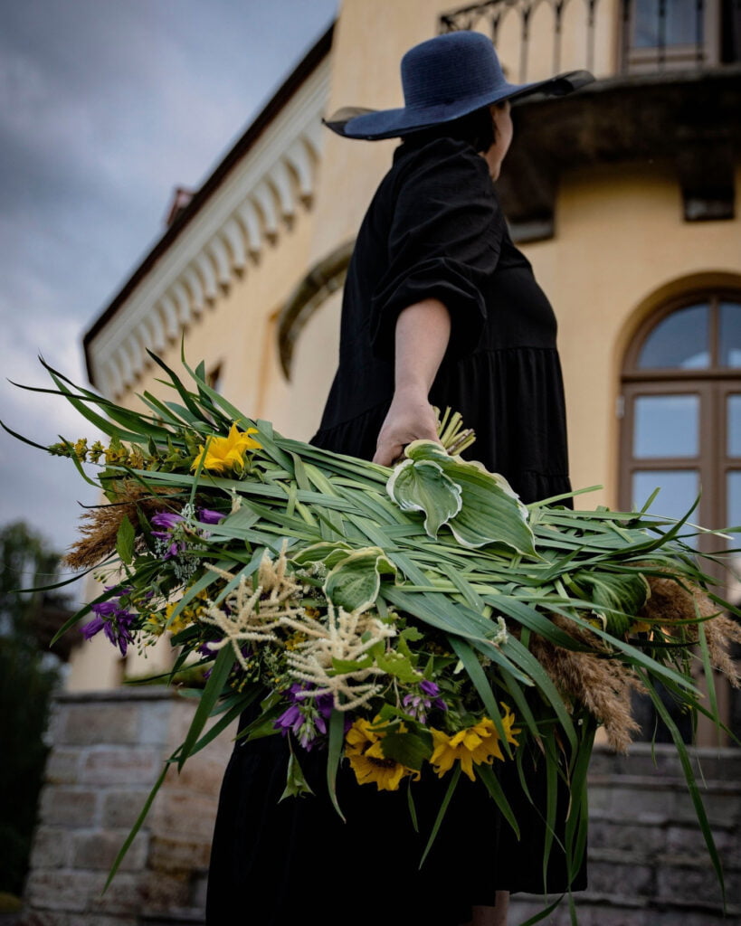 Женщина с букетом полевых цветов.