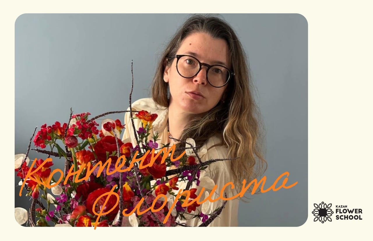 Женщина с цветами на фоне стены.